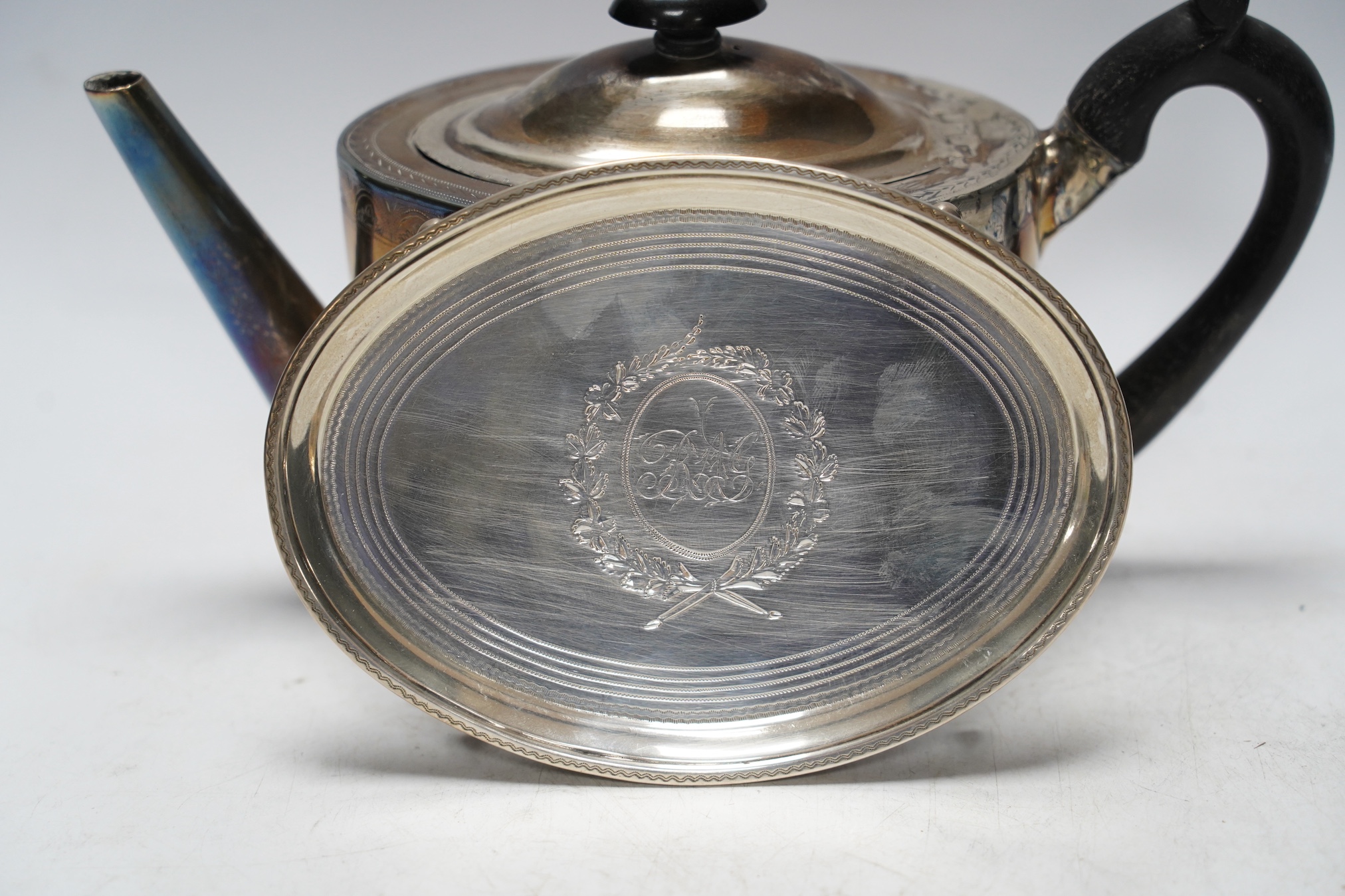 A George III engraved silver oval teapot, Cornelius Bland, London, 1791(poor condition), together with an associated oval stand (fair condition), Soloman Hougham, London, 1797, 16.2cm, gross 16oz.